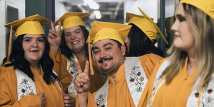 A group of college students at graduation in their yellow caps and gowns